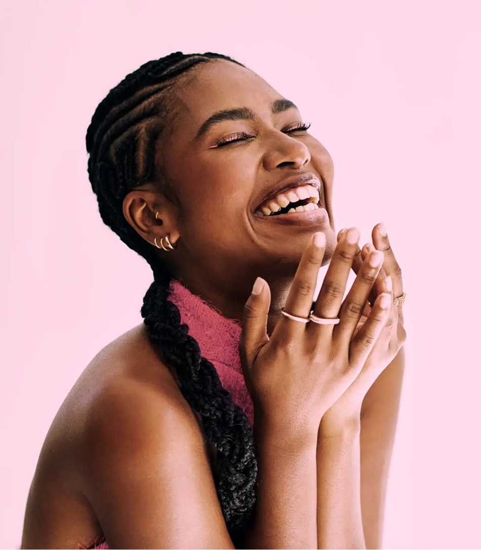 Woman joyfully laughing with clasped hands
