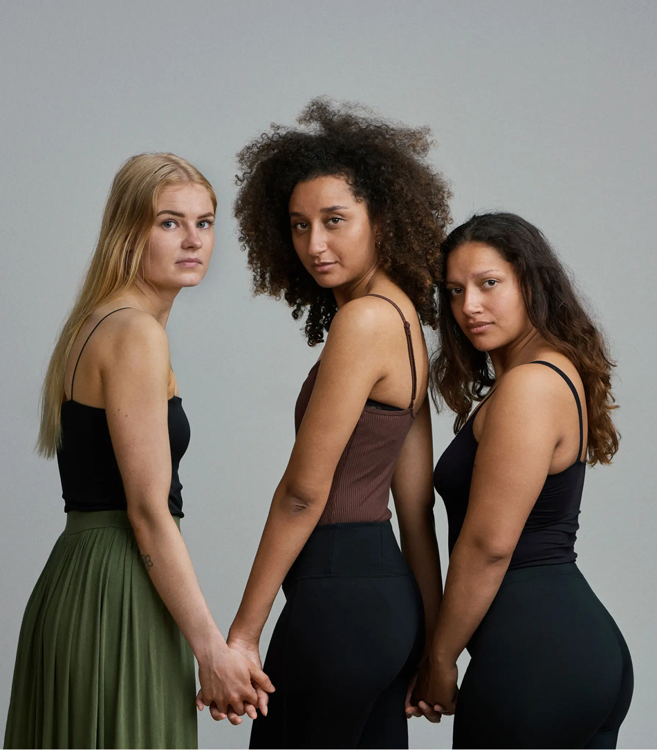Diverse women posing confidently, united stance.